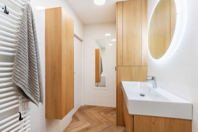 Koupelna s umyvadlem a podsvíceným zrcadlem